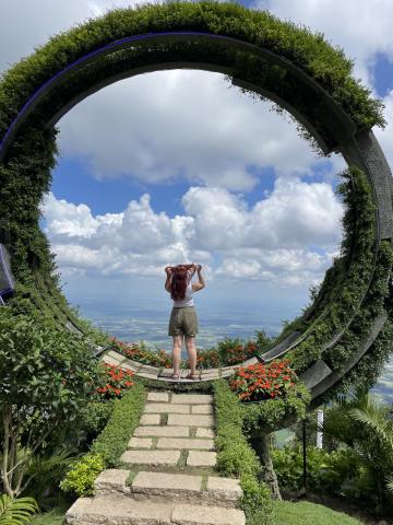 student posing under a botanical arch in Vietnam