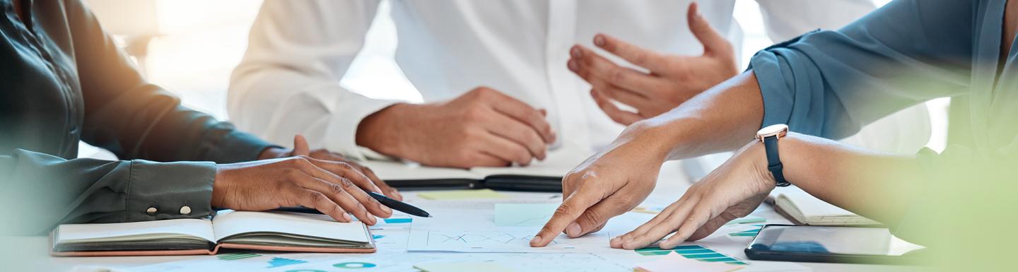 closeup of business people and team doing statistics analysis with documents and graphs.