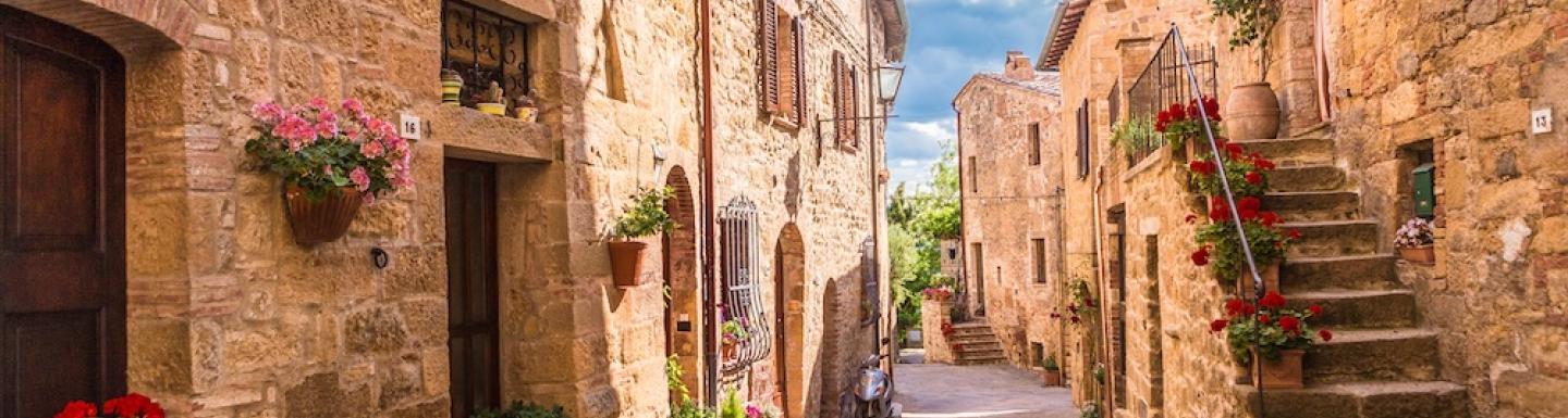 A cobblestone street with medieval era architecture in Italy