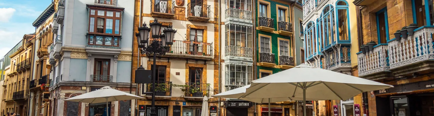 Colorful plaza in Oviedo where people are seated chatting and drinking tea