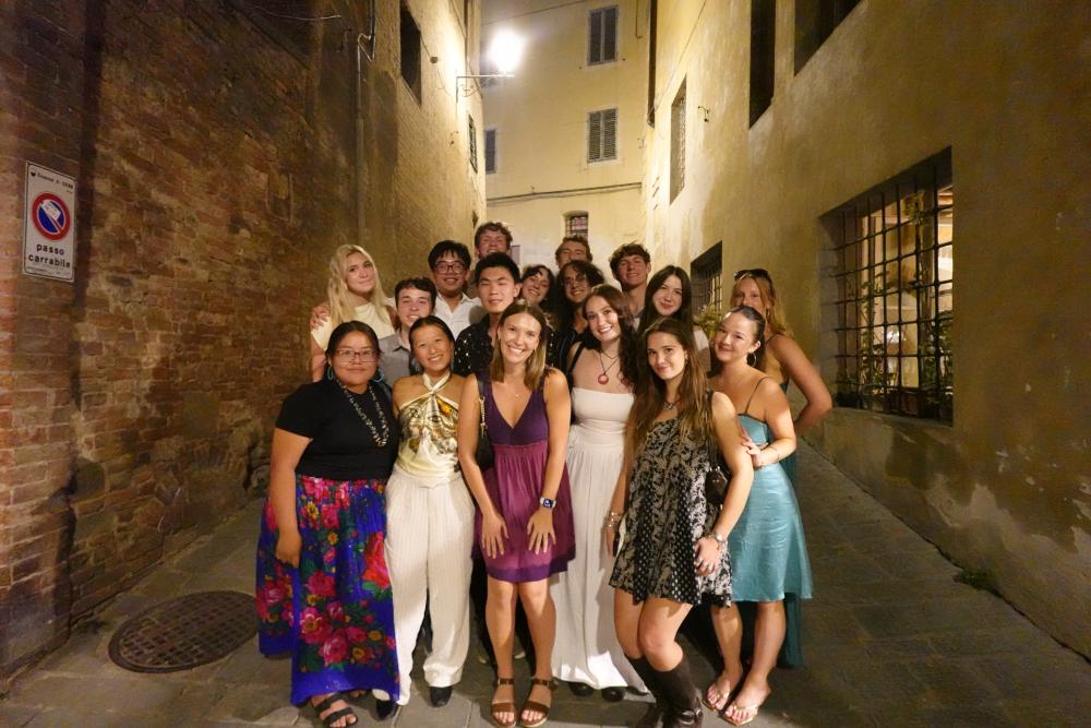 A group of UO students smiling in an alleyway