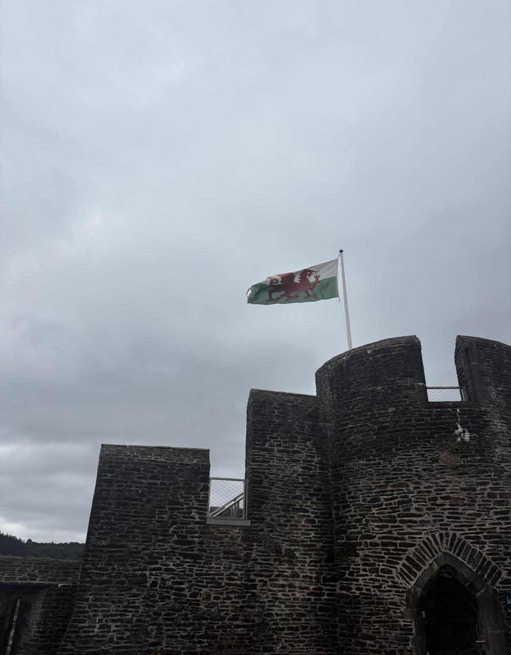 A castle in Wales with the Welsh flag