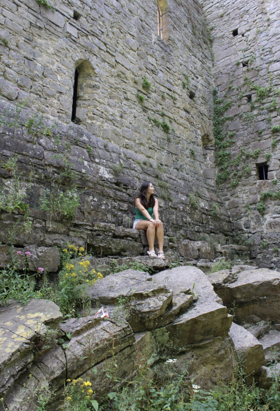 A uo student standing in front of ruins in Wales