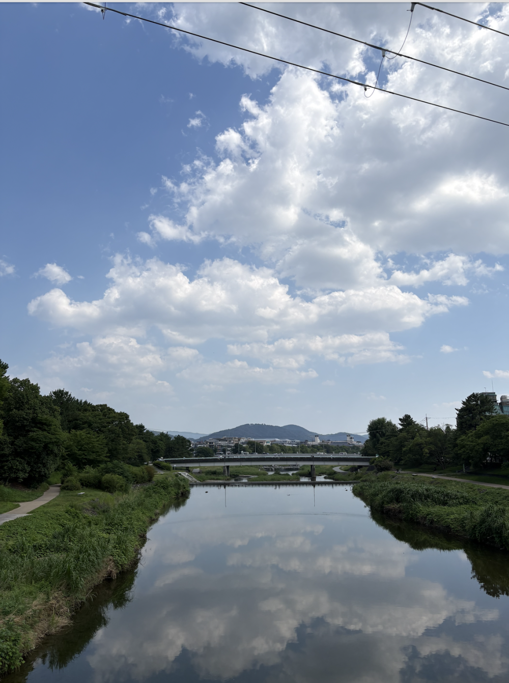 A river with a mountain range in the back in the Japanese countryside