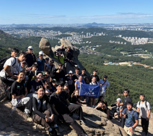 A group of students standing on rocks overlooking a city