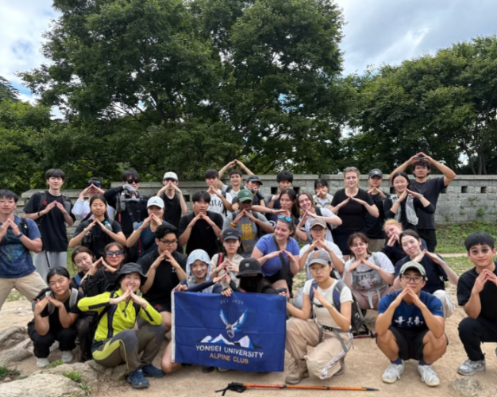 A group of students standing and posing with a blue flag