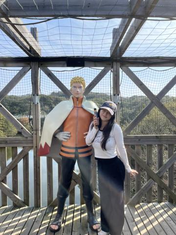 girl standing next to naruto in japan