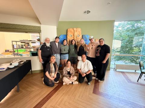 10 people stand together for a picture indoors