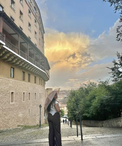 Women holding an umbrella looking back as she smiles for a picture. 