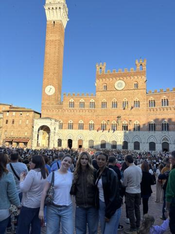 Sarah with two other students in a crowded plaza in Siena