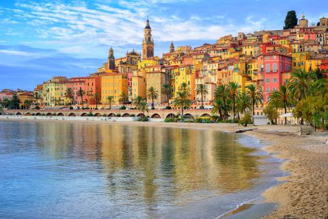 sandy beach with bright yellow and red building in the background