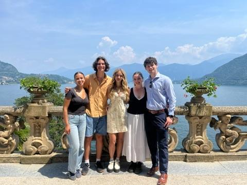 Sarah standing with 4 friends with an overlook of the sea in the bakground