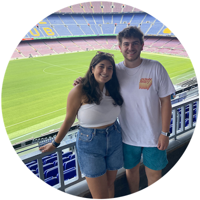 Two college aged students standing in an empty soccer stadium for professional soccer