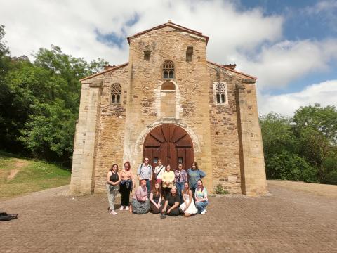 A group of college students posing in front of a medieval church in Oviedo, Spain