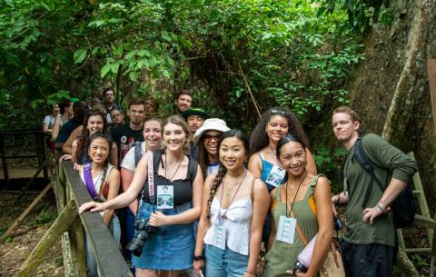 Link to external scholarships. Image description: A group of college students walking over a bridge.