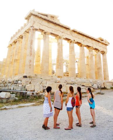 Group of 5 young woman looking up at an ancient Grecian structure in Greece