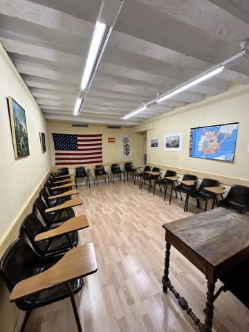 A small classroom with chairs set up in a semi circle against yellow walls