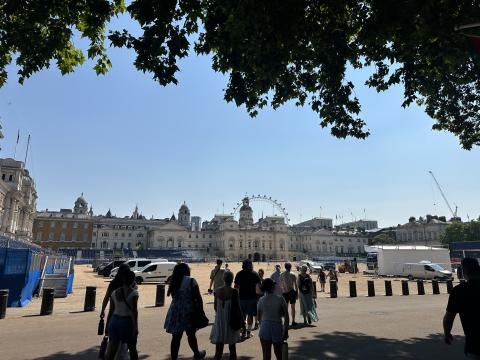 A group of people walking towards the Horse Guards Parade in London on a sunny day.