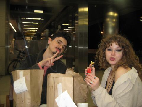 Two students sitting at a table and eating McDonalds in Spain.