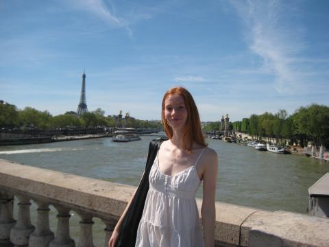 Student Emma Egbert posing on a bridge in Paris with the Eiffel tower in the background