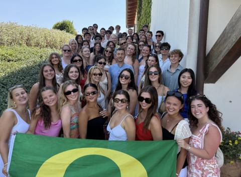Group of college students on a staircase, posing with a University of Oregon flag in Siena, Italy.