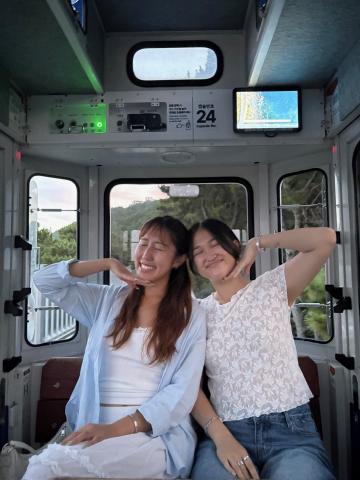 Two people pose in a capsule car