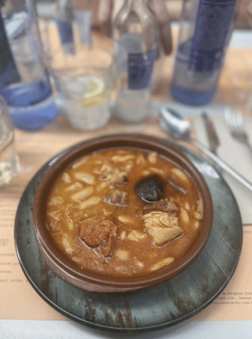 A bowl of red/brown colored stew on a table