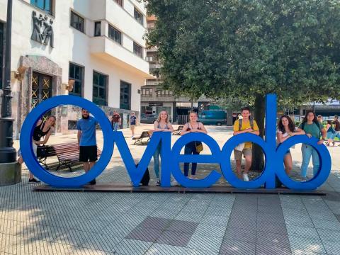 College students posing behind a sign that says Oviedo
