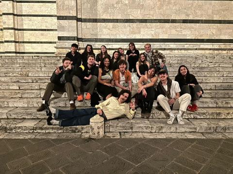 Group of University of Oregon students sitting on the steps of a plaza in Siena