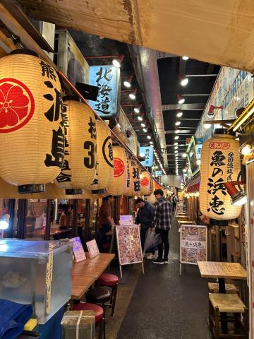 A japanese food market at night with paper lantern decorations