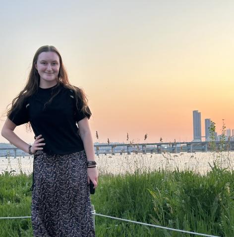 Student Zoe Tomlinson posing in front of the Tokyo skyline at sunset