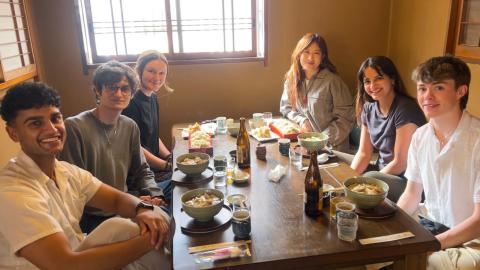 Group of college students sitting at a table and having a meal in Japan