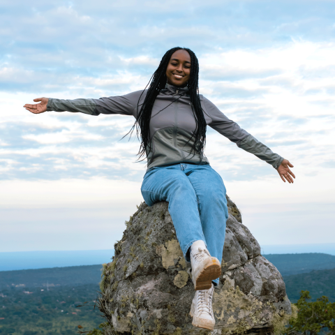 Student posing on a rock in Ghana