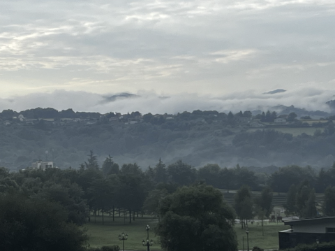 A cloudy landscape of rolling hills and trees in Oviedo