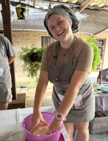 Lane wears a chef hat and mixes tortilla dough in a purple bowl