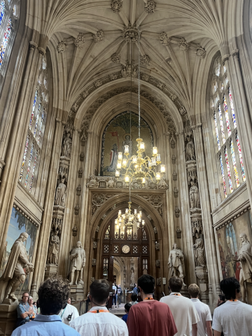 Picture of Westminster Abbey, with people at the lower third of the photo, and intricate designs in the ceiling on top