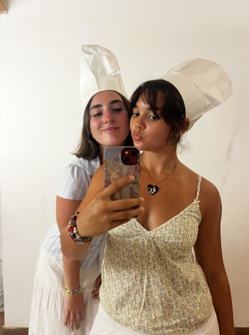 Two people in chef hats pose for a picture together