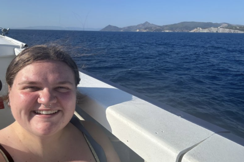 Lane on a boat with an island behind them