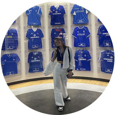 College student standing in front of a case of blue soccer jerseys