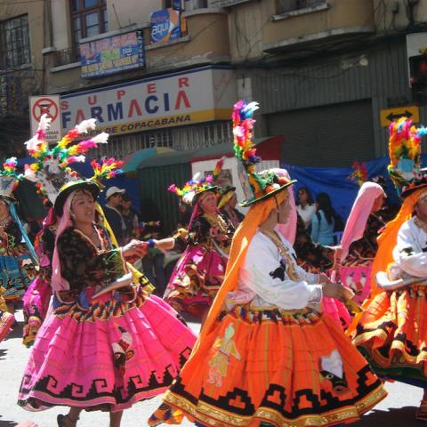 People dressed in traditional Andean clothing dancing in a parade