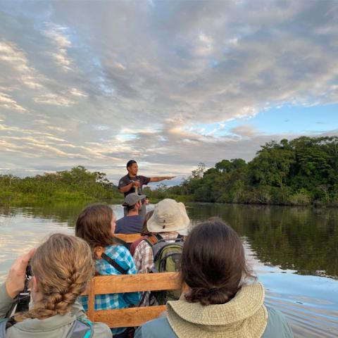 Group of Students on a boat exploring the Amazon river with a guide 