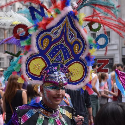 A person dressed in a mardi gras style costume celebrating pride month in London