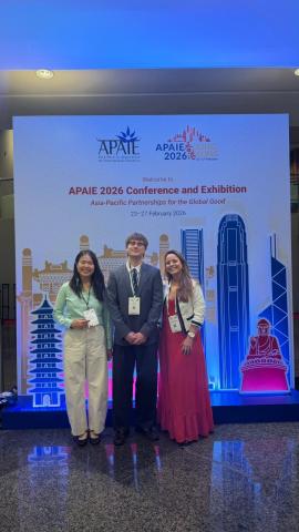 Kyler smiling with coworkers at the Asia-Pacific Pacific Partnerships for the Global Good 2026 Conference and Exhibition