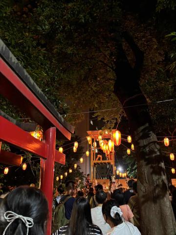 People walking in Tokyo at night with lanterns lighting the path