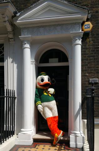 University of Oregon Duck mascot standing in front of the door of a flat in London