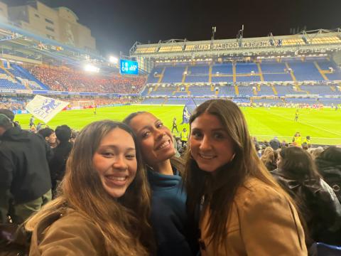 Hana taking a selfie at the Chelsea Football Club in England with two other students