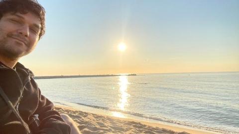 Kunal taking a selfie on a sunny beach in Barcelona, Spain.