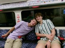 Two classmates sit together on the tube