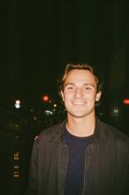 A young man stands by the city skyline