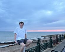 A young man sits by the Brighton coast